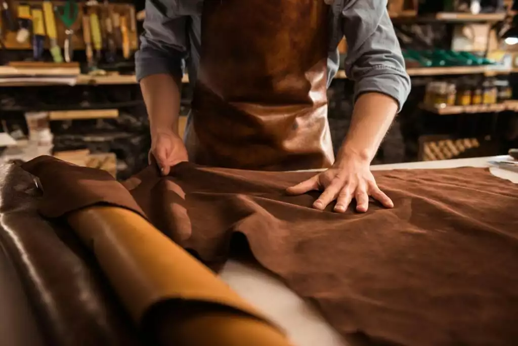 Leatherworker cutting and shaping leather at a workbench